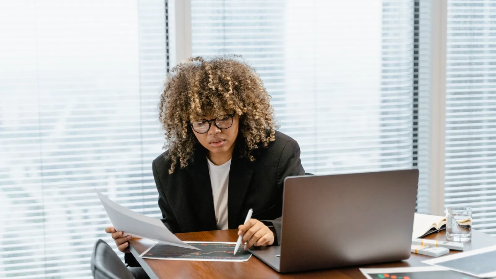 Focused marketer reviewing campaign numbers on her laptop